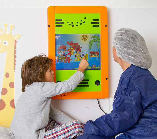 Kind en zorgverlener spelen met wandspel in ziekenhuis