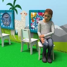 Op deze afbeelding ziet u een kind op de Buxus Chair white uit de kindermeubel collectie Buxus